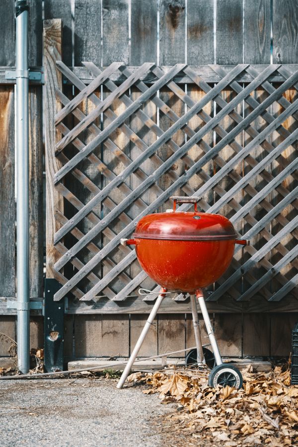 A red kettle barbecue in a garden